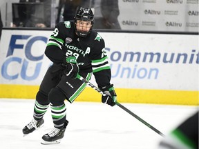 Jordan Kawaguchi of the North Dakota Fighting Hawks, right, was named the top player in the USCHO this season in a campaign cut short by the COVID-19 pandemic. He says he'll be returning to school for his senior season rather than accepting an NHL free-agent offer.