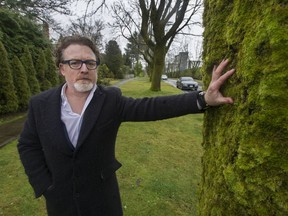 University Endowment Lands homeowner Chris Wall stands beside one of the maple trees near his house on Wesbrook Crescent in January, 2020, not long after the decision to remove 15 trees a year was announced.