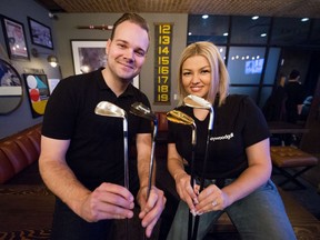 Joshua Haywood and his fiancée Haley Lloyd hold up a few of the clubs that are sold by Haywood Golf. Haywood is the founder of the company while Lloyd is responsible for all the marketing.