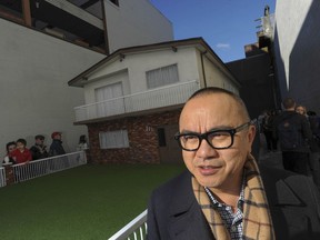 Vancouver artist Ken Lum, pictured in 2015 in front of a replica of a famed ’Vancouver Special’ house in a spare lot on Union Street in the city.