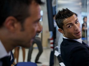 Soccer superstar Cristiano Ronaldo, right, speaks with his agent Jorge Mendes after his signing contract renewal For Real Madrid on Sept. 15, 2013 in Madrid, Spain.