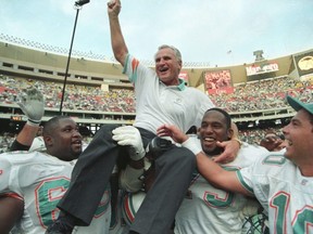 Miami Dolphins coach Don Shula is carried off the field by players Keith Sims (L) and Larry Webster (C) after Miami defeated Philadelphia 19-14 in Philadelphia November 14, 1993. This win made Shula the most successful coach in the league, giving him his 325th career victory.