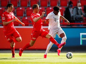 Union Berlin's Danish forward Marcus Ingvartsen (C) and Bayern Munich's Canadian midfielder Alphonso Davies (R) vie for the ball during the German first division Bundesliga football match FC Union Berlin v FC Bayern Munich on May 17, 2020 in Berlin, Germany as the season resumed following a two-month absence due to the novel coronavirus COVID-19 pandemic.