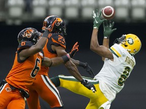 VANCOUVER July 11 2019.  Intended receiver Edmonton Eskimos #8 Kennt Stafford is unable to haul in the ball under pressure from BC Lions #6 T.J. Lee and #23 Anthony Thompson in a regular season CFL football game at BC Place.