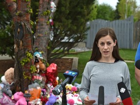 With the growing memorial in back, the mom of Bella Desrosiers, Melissa Desrosiers, reads a prepared statement on Wednesday, Mat 20, 20202, to media about the death of her daughter on Monday, May 18, 2020.