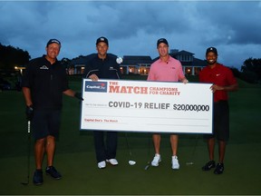 Tiger Woods (far right) and retired NFL quarterback Peyton Manning (second from right) celebrate after defeating pro golfer Phil Mickelson (far left) and NFL quarterback Tom Brady of the Tampa Bay Buccaneers on the 18th green  during The Match: Champions for Charity golf round at the Medalist Golf Club.