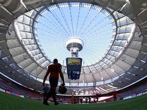 A member of the B.C. Lions walks on the B.C. Place Stadium turf for a practice, giving a glimpse of what it might be like inside the Vancouver dome if games were played there with no fans.