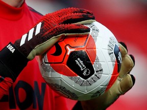 General view of a match ball held by Manchester United's David de Gea.