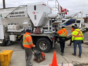 Workers get set to pour cement from a truck at the GO train station in Oakville, Ont., Tuesday, Jan.28, 2020.