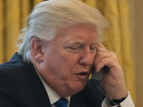 President Donald Trump speaks on the phone with Chancellor of Germany Angela Merkel in the Oval Office of the White House, January 28, 2017 in Washington, DC.