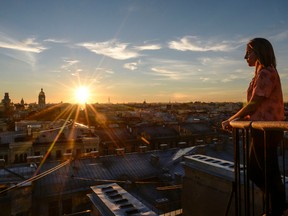 A tourist looks at the city during a visit to the first official tour of the roofs in St. Petersburg on August 11, 2017.