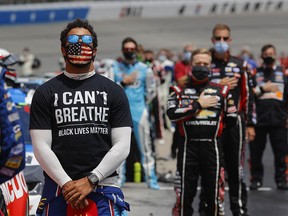 NASCAR driver Bubba Wallace wears  a Black Lives Matter" shirt under his fire suit in solidarity with protesters around the world taking to the streets after the death of George Floyd. NASCAR banned the Confederate flag from its events on Wednesday after Wallace urged the move early this week.