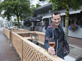 Jean-Francis Quaglia, chef/owner of Provence Marinaside, raises a glass of rosé wine while standing in one of the patio areas installed outside his Vancouver restaurant on June 10.