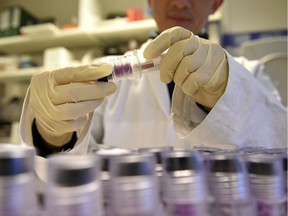 (FILES) This file photo taken on December 15, 2015 shows a technician holding blood samples about to be tested at the French national anti-doping laboratory, in Chatenay-Malabry, outside Paris.