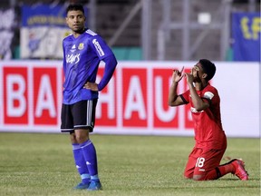 Saarbrücken's Kianz Froese, left, stands as Leverkusen's Brazilian defender Wendell celebrates his team's third goal in the German Cup (DFB Pokal) semifinal in Volklingen, southern Germany on Tuesday.