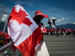 Summer Shen waves a Canadian flag while sporting a patriotic outfit during Canada Day celebrations in Vancouver, on July 1, 2019.