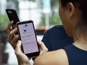 A contact-tracing smartphone app to use for COVID-19 deploying Bluetooth technology is demonstrated in Singapore on March 20.