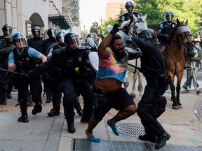 Riot police chase a man as they rush protestors to clear Lafayette Park and the area around it across from the White House for President Donald Trump to be able to walk through for a photo opportunity in front of St. John's Episcopal Church, during a rally against the death in Minneapolis police custody of George Floyd, near the White House, in Washington, U.S. June 1, 2020. REUTERS/Ken Cedeno