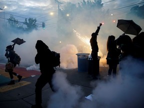 FILE PHOTO: Protesters disperse as tear gas, pepper spray and flash-bang devices are deployed by Seattle police during a protest against police brutality and the death in Minneapolis police custody of George Floyd, in Seattle, Washington, U.S. June 1, 2020. REUTERS/Lindsey Wasson/File Photo