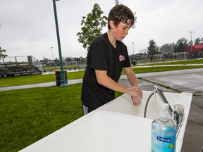 Surrey United U14 boys player Charlie Padberg washes his hands prior to practice.