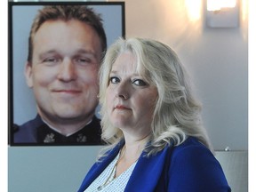 Dalila Vroom stands in front of a photo of her late husband, Const. Rob Vroom.