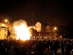 Protesters gather around after setting fire to the entrance of a police station in Minneapolis, Minnesota, May 28, 2020.
