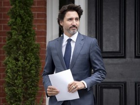 Prime Minister Justin Trudeau makes his way to the podium for a news conference outside Rideau Cottage in Ottawa, Thursday, June 25, 2020.