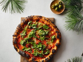Arugula, green olives and cherry tomatoes crown David Hawksworth’s Roman-style pizza. Photo: Kevin Clark.