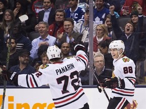 Chicago Blackhawks right wing Patrick Kane (88) celebrates his hat trick against the Toronto Maple Leafs with teammate Artemi Panarin (72) during third period NHL hockey action in Toronto on Friday, January 15, 2016. THE CANADIAN PRESS/Nathan Denette