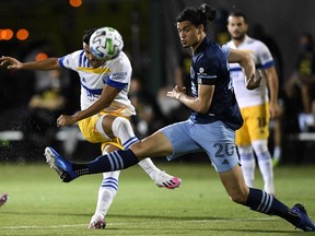 Andres Rios of the San Jose Earthquakes, right, looks to kick the ball as Jasser Khmiri of the Vancouver Whitecaps defends at the MLS is Back Tournament in Reunion, Fla. on July 15.