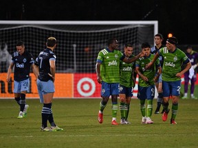 The Seattle Sounders celebrate a goal against the Vancouver Whitecaps FC during Sunday night's Group B match as part of MLS is Back Tournament at ESPN Wide World of Sports Complex in Reunion, Fla.