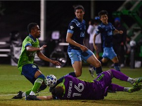 Vancouver Whitecaps goalkeeper Max Crepeau sustains an injury on a save against Nicolas Lodeiro of the Seattle Sounders FC during a Group B match as part of MLS is Back Tournament at ESPN Wide World of Sports Complex on Sunday night in Reunion, Florida.