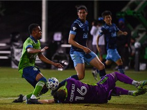 Vancouver Whitecaps keeper Max Crepeau sustains an injury on a save against Nicolas Lodeiro of Seattle Sounders FC during a Group B match as part of the MLS is Back Tournament at the ESPN Wide World of Sports Complex in Reunion, Fla.