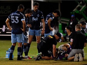 The medical staff and members of the Vancouver Whitecaps huddle around goalkeeper Max Crepeau after he was injured against the Seattle Sounders FC in Reunion, Fla., on Sunday.