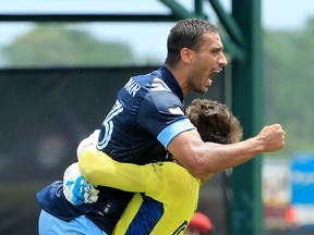 Ali Adnan of Vancouver Whitecaps jumps on netminder Thomas Hasal following Thursday's Group B victory against the Chicago Fire in the MLS Is Back Tournament at ESPN Wide World of Sports Complex in Orlando, Fla.