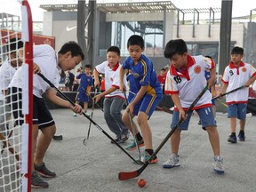 Youngsters play hockey at the NHL Fan Fest in Beijing, China before the NHL pre-season game between the Los Angeles Kings and the Vancouver Canucks at Wukesong Arena on Sept. 23, 2017.