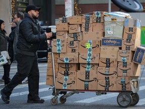 A delivery person pushes a cart full of Amazon boxes in New York City, Feb. 14, 2019.