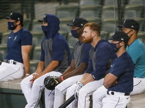 Seattle Mariners catcher Brian O'keefe (64, no mask) watches a live batting practice session with teammates including pitcher Justus Sheffield (33, right) at T-Mobile Park.