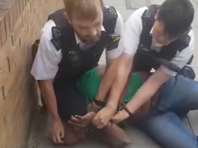 A video reportedly shows a British police officer placing his knee on a Black mans neck.