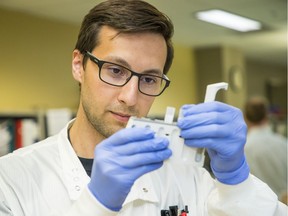 B.C. Centre of Disease Control medical tech Jesse Kustra demonstrates testing for antibodies in blood on July 22 to try to track the history of the COVID-19 virus's spread in the population.