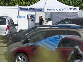 Members of IHIT and Burnaby Fire and Rescue Services investigate Thursday morning after a body was found in a car at Mundies Towing yard in Burnaby.