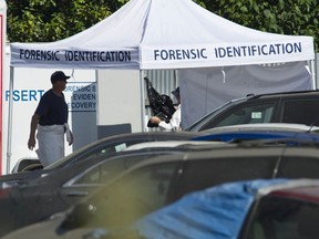 Members of IHIT and Burnaby Fire and Rescue Services investigate Thursday morning, July 30, 2020 after a body was found in a car at Mundies Towing yard in Burnaby, BC Wednesday.