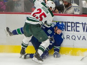 Vancouver Canucks Elias Pettersson is pasted up against the boards by Minnesota Wild's Jonas Brodin at Rogers Arena on February 19, 2020.