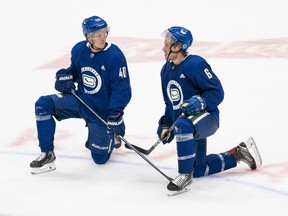 Vancouver Canucks Elias Pettersson (left) and Brock Boeser talk after the second session on the first day of training camp at Rogers Arena on Monday.