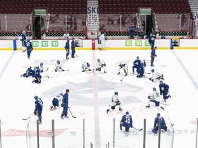 The Vancouver Canucks stretch and cool down after the second session on the first day of training camp at Rogers Arena on Monday