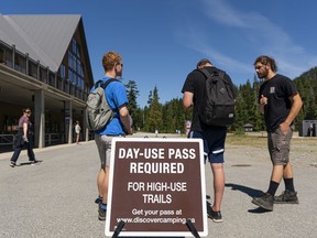 Hikers show their "Day-Use" pass to James Tammaro of Cypress Mountain before they can start their day at Cypress Provincial Park in West Vancouver on Monday.