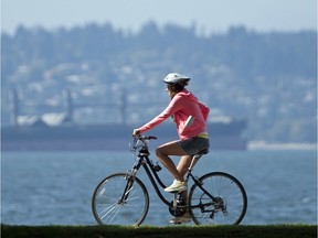 A cyclist rides along the seawall at Second Beach in Stanley Park.