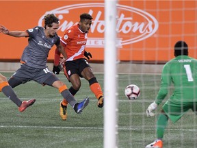 Cavalry FC forward Dominique Malonga (23) shoots the ball past Forge FC defender Klaidi Cela in the second half of a Canadian Premier League last October. The two teams, which met in the inaugural championship series, will open The Island Games, the CPL's return-to-play tournament set to start Aug. 13 in Charlottetown, P.E.I.