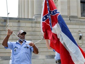 Willie Townsend, an employee of the Mississippi State Capitol, raises and lowers commemorative State flags that are purchased by people from all around the world after being flown at the Capitol, hours before Mississippi Governor Tate Reeves signed a bill into law replacing the current state flag that includes a Confederate emblem, in Jackson, Mississippi, U.S., June 30, 2020.