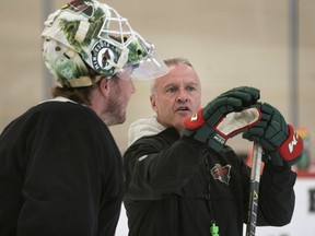Minnesota Wild coach Dean Evason talks with goalie Devan Dubnyk before practice started at the NHL hockey team's training camp Monday, July 13, 2020, in St. Paul, Minn., after a break in the season because of the coronavirus pandemic.